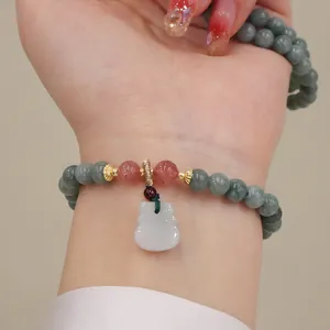 Vista dettagliata di un bracciale di giada e quarzo fragola con ciondolo a sacchetto.