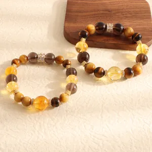 Close-up of natural tiger's eye and citrine beaded bracelets with golden spacers