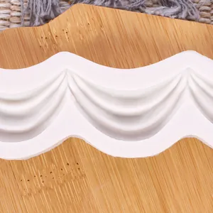 Close-up detail showing intricate wave curtain patterns on a white silicone fondant mold