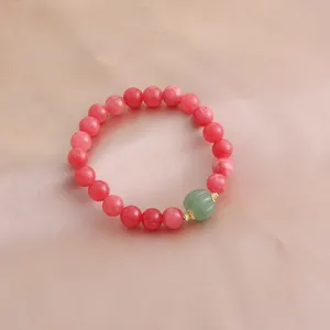 Detailansicht eines Armbands aus rosa Rhodochrosit mit grüner Kürbis-Achatperle