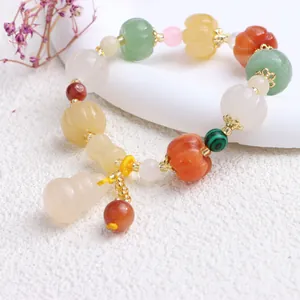 Detailansicht eines ethnischen Jade-Armbands mit geschnitzten Kürbis- und hulu-Anhängern