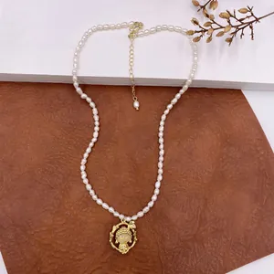 Detail view of retro baroque pearl necklace featuring a cute golden monk pendant detail