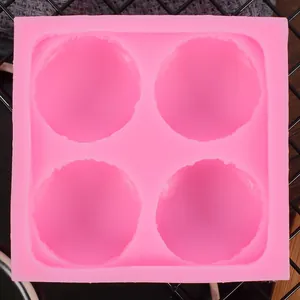 Macro-opname van een roze siliconen macaronvorm met 4 gaten op een zwart koelrekje