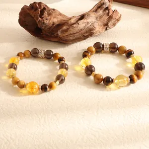 Natural tiger eye and yellow crystal stone beaded bracelets styled on natural wood background