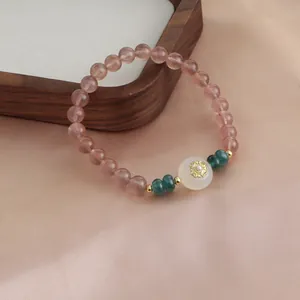 Macro view of natural strawberry quartz bracelet with elegant gold floral center bead