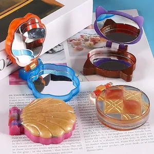 Close-up detail of colorful DIY resin craft mirrors in shell and cat-ear designs