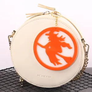 Round white bag featuring an orange silicone Halloween witch charm decoration