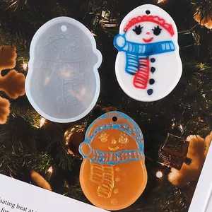 Detail view of snowman silicone mold and finished resin pendants on a Christmas tree.
