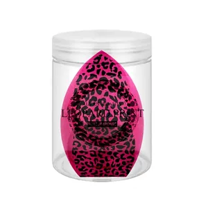 Macro view of a pink leopard print makeup sponge inside a transparent storage jar.