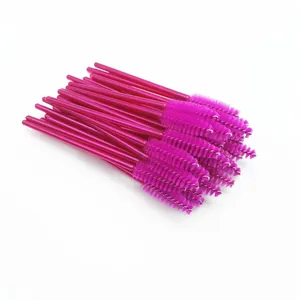 Detailed view of high-quality bright pink disposable eyelash brushes in a large bundle