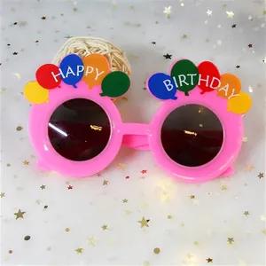 Vue détaillée de lunettes de fête d'anniversaire roses avec des ballons colorés.