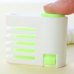 Macro detail of multi-layer cake slicer guide with adjustable green buttons