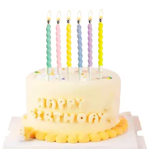 Set of six colorful spiral birthday candles lit on a cake for party decoration