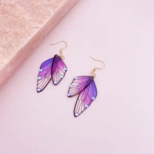 Macro detail view of purple gradient butterfly wing earrings with delicate glitter accents.