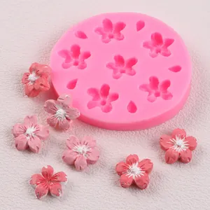 Detailed view of pink cherry blossom silicone mold with finished floral fondant decorations.