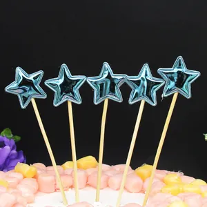 Detalle macro de cinco adornos para tarta de estrella azul metálico en palos naturales