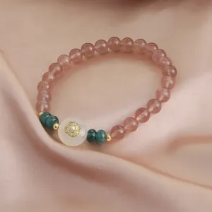 Exquisite detail of a natural strawberry quartz bracelet with green accent beads