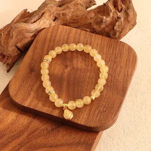 Detaillierte Ansicht des gelben Citrin-Armbands mit goldenem Anhänger auf Holz