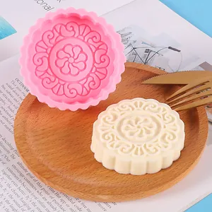 Detail showing intricate floral patterns of a mooncake-shaped silicone mold and wax melt.