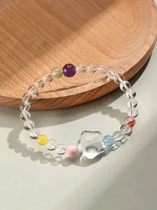 Gros plan d'un bracelet en cristal blanc avec des gemmes colorées et un charme étoile