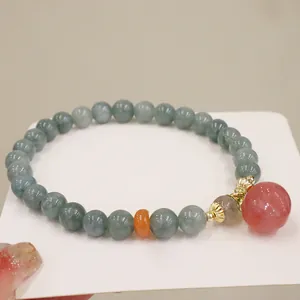 Vista dettagliata del bracciale di perle di giada da donna con grande ciondolo di quarzo fragola.