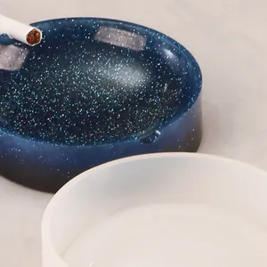 Detailansicht einer weißen Silikonform für Aschenbecher mit einem blauen Glitzerharz-Produkt.