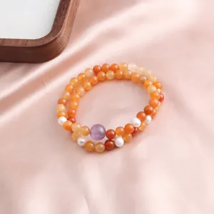 Close-up of a double-strand beaded bracelet with orange jade, pearls and purple crystal