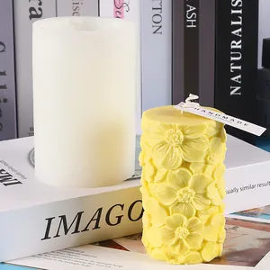 Détail du moule en silicone cylindrique et bougie jaune avec relief floral en 3D.