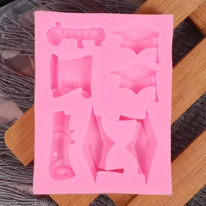 Close-up detail of pink silicone mold featuring graduation cap and diploma carved shapes