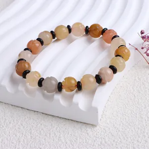 Detailaufnahme eines natürlichen Goldseiden-Jade-Armbands mit Kürbisperlen-Schnitzerei