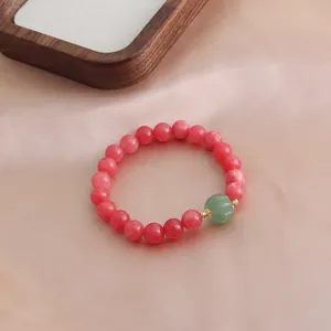 Detailansicht eines Armbands aus Rhodochrosit-Perlen mit grünem Achat-Kürbis Anhänger