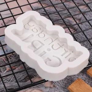 Dettaglio di uno stampo in silicone bianco Happy Birthday per decorare torte al cioccolato