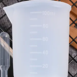 Detalle de una taza medidora de silicona de 100 ml con marcas de escala en relieve precisas