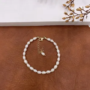 Macro view of a vintage natural white pearl necklace with gold lobster clasp and extension