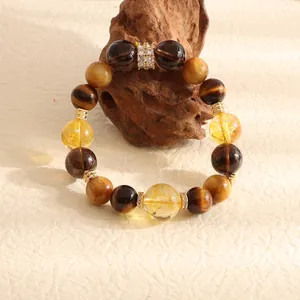 High-quality close-up of natural tiger's eye and citrine beaded bracelet on rustic wood