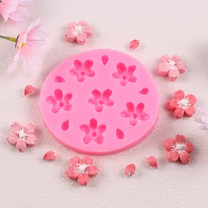 Close-up view of pink cherry blossom silicone mold with finished decorative flower samples