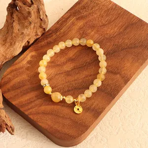 Elegante Nahaufnahme eines Citrin-Armbandes mit goldenem Münzanhänger aus Quarzperlen