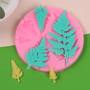 Vista detallada del molde de silicona rosa para hojas de helecho con muestras de fondant.