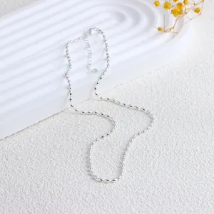 Detailansicht einer minimalistischen silbernen Reiskorn Halskette auf weißem Displayständer