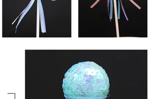 Close-up of a blue sequined sphere cake topper with colorful hanging ribbons.