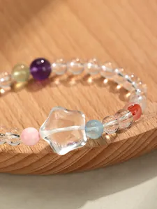 Gros plan d'une breloque en cristal blanc en forme d'étoile et de perles colorées