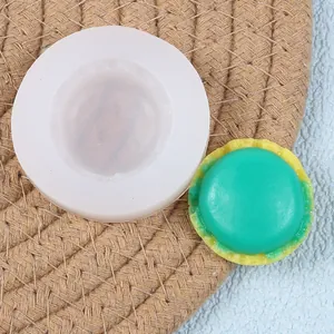 Gedetailleerd overzicht van een siliconen macaronvorm met een afgewerkte groene taart