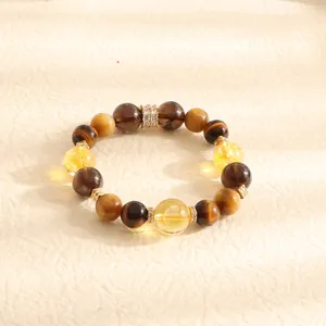 Macro view of a natural tiger eye and citrine beaded bracelet with gold crystal spacers