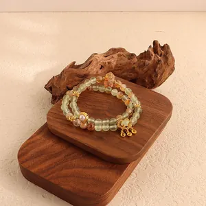 Detailed view of a New Chinese style green fluorite bracelet with golden pagoda charms