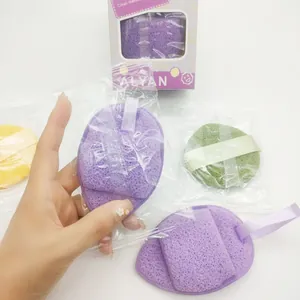 Close-up of a 3-piece facial cleaning sponge set featuring purple and green sponges in a hand