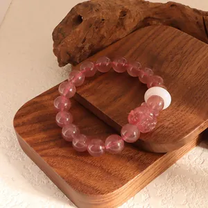 Detailed view of pink strawberry quartz beaded bracelet with carved nine-tailed fox charm