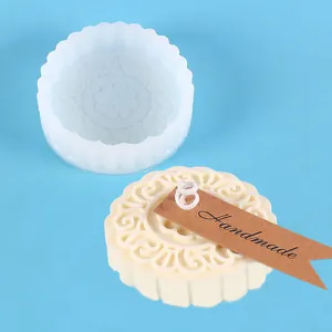 Detail view of mooncake-shaped silicone mold showing intricate floral patterns and candle