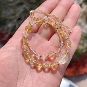 Close-up detail of faceted yellow citrine crystal beads on an adjustable bracelet