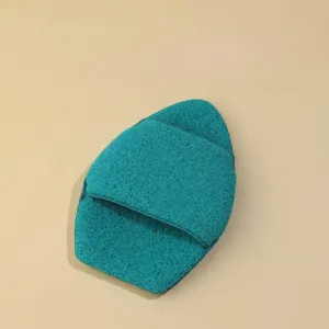 Macro detail showing the porous texture of a teal thickened glove facial cleansing sponge