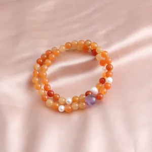 Detail view of a double-strand jade bracelet with pearls and amethyst on pink satin.